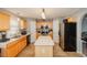 Bright kitchen featuring light wood cabinetry, an island, stainless steel appliances, and tile flooring at 1808 Ashton E Dr, St Cloud, FL 34771