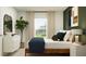 Comfortable bedroom featuring a bed with blue and white linens, a dresser, a large window, and green accent wall at 2109 Lasso Loop, Eagle Lake, FL 33839