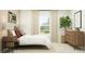 Inviting bedroom with a cozy bed, side table, large window, and dresser with plant, offering a relaxing personal space at 2109 Lasso Loop, Eagle Lake, FL 33839