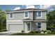 Charming two-story home with a combination of gray siding and stone, complemented by a well-manicured lawn at 2302 Cypress Creek St, Auburndale, FL 33823
