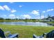 Picturesque backyard with pond views and blue Adirondack chairs at 1322 Aguacate Ct, Orlando, FL 32837