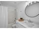 Bathroom featuring a round mirror and shower-tub combo at 1322 Aguacate Ct, Orlando, FL 32837
