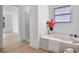 Bright bathroom featuring a soaking tub, separate shower, and wood-look vinyl flooring at 1322 Aguacate Ct, Orlando, FL 32837