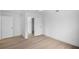 Minimalist bedroom with light wood-look floors and multiple doorways at 1322 Aguacate Ct, Orlando, FL 32837