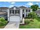 Two story home featuring a gray exterior with white trim, black shutters, a manicured lawn, and a two-car garage at 1322 Aguacate Ct, Orlando, FL 32837