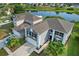 An aerial view of a two-story home with a gray exterior, black shutters, two-car garage, and a pond view at 1322 Aguacate Ct, Orlando, FL 32837