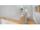 Bright hallway featuring a wood railing and vinyl flooring at 1322 Aguacate Ct, Orlando, FL 32837
