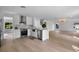 Modern kitchen with stainless steel appliances, white cabinetry, and light wood flooring open to the living space at 1322 Aguacate Ct, Orlando, FL 32837