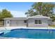 An inviting in-ground pool surrounded by a concrete patio, complemented by the home's gray exterior at 14464 Sw 34Th Terrace Rd, Ocala, FL 34473
