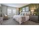 Beautiful bedroom with a large bed, gray carpet, and an accent wall with two windows to let in natural light at 2507 Peace Of Mind Ave, Kissimmee, FL 34744