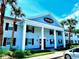 The Stratford condominium complex with well-maintained landscaping, palm trees, and a bright blue entrance at 296 Lewfield Cir, Winter Park, FL 32792