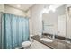 Bathroom with granite vanity, framed mirror, and decorative blue shower curtain at 3184 Whispering Trails Ave, Winter Haven, FL 33884
