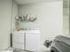 Laundry room with white washer and dryer and gray floors at 3184 Whispering Trails Ave, Winter Haven, FL 33884