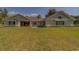 Lovely backyard view of the home with expansive green lawn, and covered patio for outdoor living at 4004 Se 47Th Pl, Ocala, FL 34480