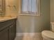 Bathroom featuring a gray vanity cabinet with marble countertop and framed mirror at 4004 Se 47Th Pl, Ocala, FL 34480