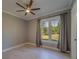 Light-filled bedroom with a ceiling fan, large window, and light gray walls and floors at 4004 Se 47Th Pl, Ocala, FL 34480