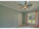 Cozy bedroom with a tray ceiling, fan, window, and stylish trim at 4004 Se 47Th Pl, Ocala, FL 34480