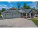 Craftsman home with a three-car garage, covered porch, stone accents, and lush landscaping at 4004 Se 47Th Pl, Ocala, FL 34480