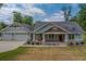 Craftsman home with a three-car garage, covered porch, stone accents, and lush landscaping at 4004 Se 47Th Pl, Ocala, FL 34480