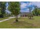 Lovely home with lush lawn, mature trees, and a circular driveway at 4004 Se 47Th Pl, Ocala, FL 34480