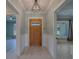 Inviting foyer with wood-look tile flooring, a craftsman front door, and decorative lighting at 4004 Se 47Th Pl, Ocala, FL 34480