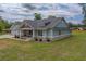 This single Gathering home features light-green siding, a stone foundation, and a covered porch with a welcoming entrance at 4004 Se 47Th Pl, Ocala, FL 34480