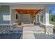 Charming front porch with porch swing, stone accents, and wood ceiling, ideal for relaxing outdoors at 4004 Se 47Th Pl, Ocala, FL 34480