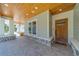 Covered front porch with wooden ceiling, white columns, stone accents, and custom front door at 4004 Se 47Th Pl, Ocala, FL 34480