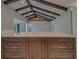 Close-up of a kitchen island with light countertops and views of a vaulted ceiling with beams at 4004 Se 47Th Pl, Ocala, FL 34480