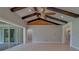 Open living room with wood beam ceilings, recessed lighting, and sliding glass doors to the lanai at 4004 Se 47Th Pl, Ocala, FL 34480