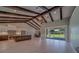 Open-concept living area with wood beam ceilings, flowing into the kitchen and dining spaces at 4004 Se 47Th Pl, Ocala, FL 34480