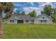 Lovely single-Gathering home features a charming light-green exterior, stone foundation, large windows, and expansive green lawn at 4004 Se 47Th Pl, Ocala, FL 34480