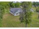 Property includes a light-green home featuring stone foundation, expansive lawn, and is surrounded by a beautiful canopy of mature trees at 4004 Se 47Th Pl, Ocala, FL 34480