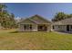 Exterior showcasing large windows, stone accents, light blue siding, and a well-maintained lawn at 4004 Se 47Th Pl, Ocala, FL 34480