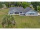 Aerial view of a single-Gathering home featuring a light-green exterior, stone accents, and a generous backyard with natural landscaping at 4004 Se 47Th Pl, Ocala, FL 34480