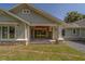 Covered back patio with ceiling fan and large windows, perfect for enjoying outdoor living and entertaining at 4004 Se 47Th Pl, Ocala, FL 34480