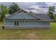 Home's light-green siding and stone foundation pair perfectly with the large windows, creating a tranquil and nature-filled view at 4004 Se 47Th Pl, Ocala, FL 34480