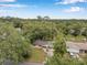 An aerial view shows the home surrounded by mature trees in a peaceful, residential neighborhood at 1123 Enchanted Dr, Lakeland, FL 33801