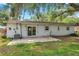 The backyard features a concrete patio, a few trees, and a sliding glass door entrance at 1123 Enchanted Dr, Lakeland, FL 33801