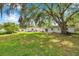 The expansive, grassy backyard includes a patio area and mature trees, offering ample space at 1123 Enchanted Dr, Lakeland, FL 33801
