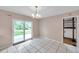 Dining room features tile flooring, a chandelier, and sliding glass doors to the outside at 1123 Enchanted Dr, Lakeland, FL 33801