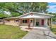 Single-story brick home with red shutters, covered carport, and manicured lawn at 1123 Enchanted Dr, Lakeland, FL 33801