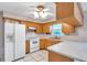 Bright kitchen featuring wooden cabinetry, tile floors, and modern appliances at 1123 Enchanted Dr, Lakeland, FL 33801