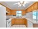 Well-lit kitchen with wooden cabinetry, white appliances, and a window over the sink at 1123 Enchanted Dr, Lakeland, FL 33801