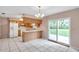Open kitchen with tile flooring, wood cabinets, and sliding glass doors to the backyard at 1123 Enchanted Dr, Lakeland, FL 33801