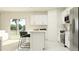 Modern white kitchen featuring stainless steel appliances, a four-seater island, and sliding glass doors at 1393 Acorn Meadow Loop, Eustis, FL 32726