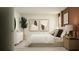 Modern bedroom with neutral tones, stylish art, decorative tree, and ample natural light at 1393 Acorn Meadow Loop, Eustis, FL 32726