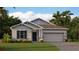 Charming single-story home with a two-car garage, well-maintained lawn, and beautiful landscaping at 2853 Haze Rd, Clermont, FL 34714