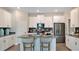 Modern kitchen with white cabinets, stainless steel appliances, island with seating, and stylish backsplash at 2853 Haze Rd, Clermont, FL 34714