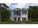 Charming two-story home featuring a stylish blue exterior, complemented by a well-maintained lawn and lush landscaping at 2899 Transformation Way, Clermont, FL 34714